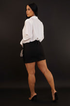 Woman wearing a white blouse and black skirt against a plain background