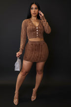 Woman wearing a brown knit outfit against a plain background.